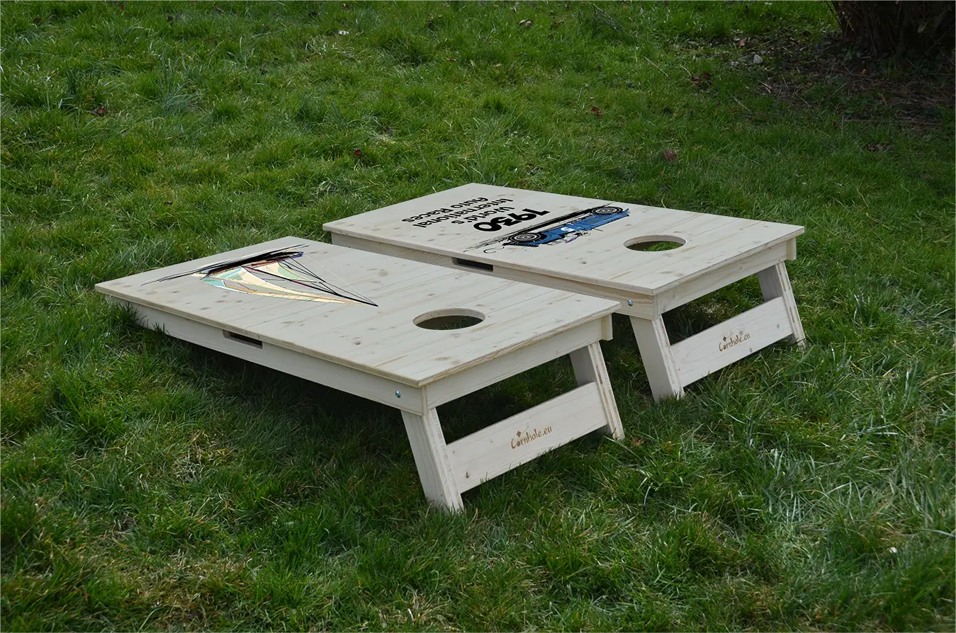 cornhole 2 planches motifs personnalisables sur fond de bois naturel, sur le gazon, vue de derrière