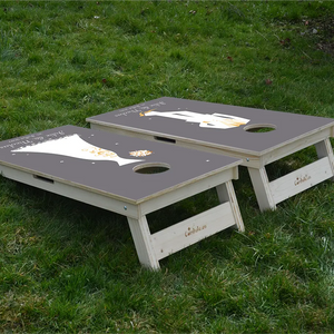 cornhole 2 planches marié et mariée, avec inscription de leurs prénoms et de la date de leur mariage, sur le gazon, vue de derrière