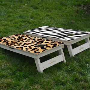 cornhole 2 planches pelage de zèbre et panthère, sur le gazon, vue de derrière