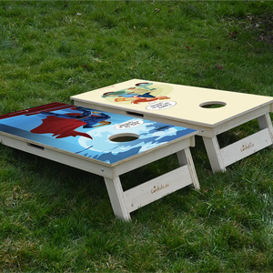 cornhole 2 planches super héro sur toit et couple d'amoureux sur un scooter, sur le gazon, vue de derrière