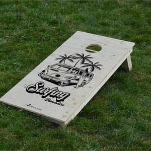 cornhole van vw de surf avec sa planche accolée sous les palmiers, sur le gazon, vue de face