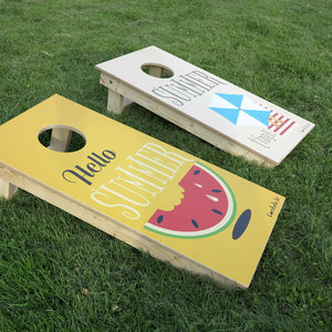 cornhole 2 planches format voyage plage et pastèque, sur le gazon, vue de derrière