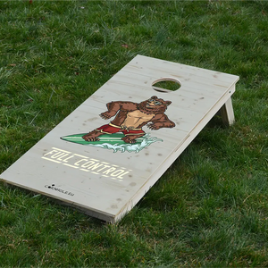 cornhole ours en short de bain sur une planche de surf, sur le gazon, vue de face