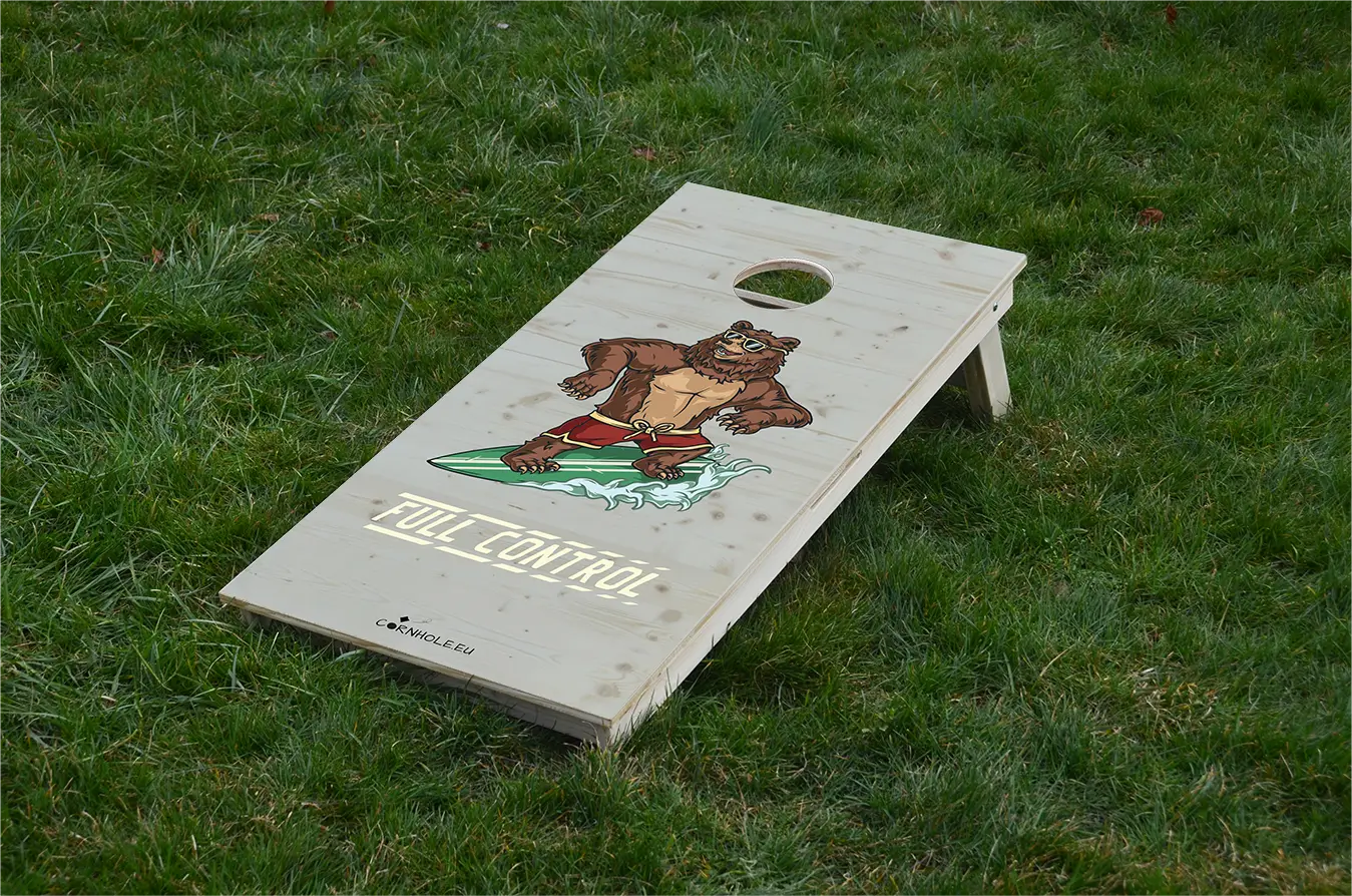 cornhole ours en short de bain sur une planche de surf, sur le gazon, vue de face