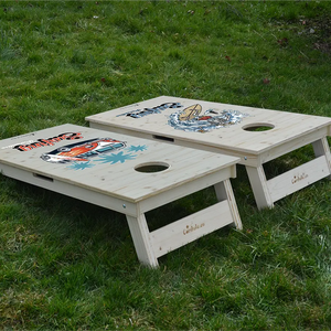 cornhole 2 planches van de surf et squelette surfant une vague, sur le gazon, vue de derrière