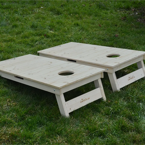 cornhole 2 planches bois naturel, sur le gazon, vue de derrière