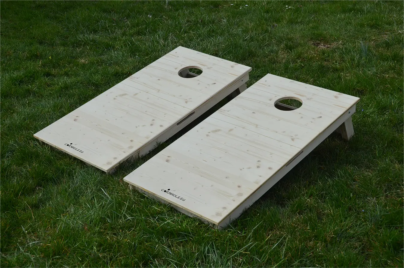 cornhole 2 planches bois naturel, sur le gazon, vue de face